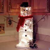 glass block snowman on a kitchen counter with lights 