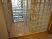 glass block shower walls and a frameless glass door