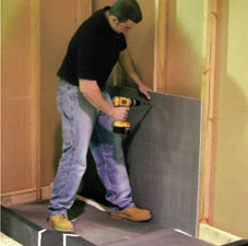 waterproof wall board being installed on wood studs