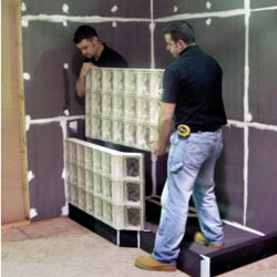 prefabricated glass block wall sections being installed and anchored to a wall 