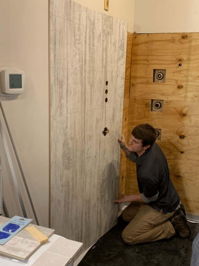 A laminated wall panel being installed click and lock system | Innovate Building Solutions | #LaminateWallPanels #ShowerWallPanels #BathroomWallPanels #ClickTogetherPanels