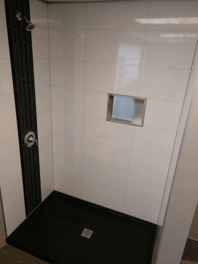 Laminate shower wall kit with a tile look recessed niche | Innovate Building Solutions | #LaminateShowers #WallPanelsKit #BathroomWallPanels