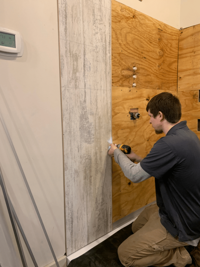 Laminated shower and bathroom wall panel being installed | Innovate Builders Blog | Innovate Building Solutions | #LaminateShower #BathroomShowerWalls #InstallingPanels