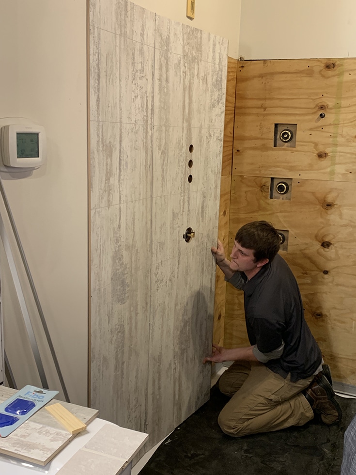 Tongue and groove laminate shower wall panels being installed | Innovate Building Solutions | Innovate Builders Blog | #LaminateWallPanels #InstallationTips #BathroomRemodeling #RemodelingContractors