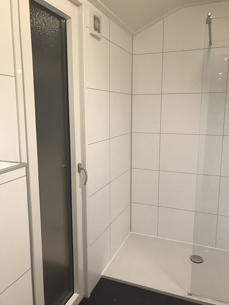 Laminate shower look like tile in a European bathroom | Innovate Builders Blog | Innovate Building Solutions | #LaminateShowerWalls #TileShower #EuropeanShower 