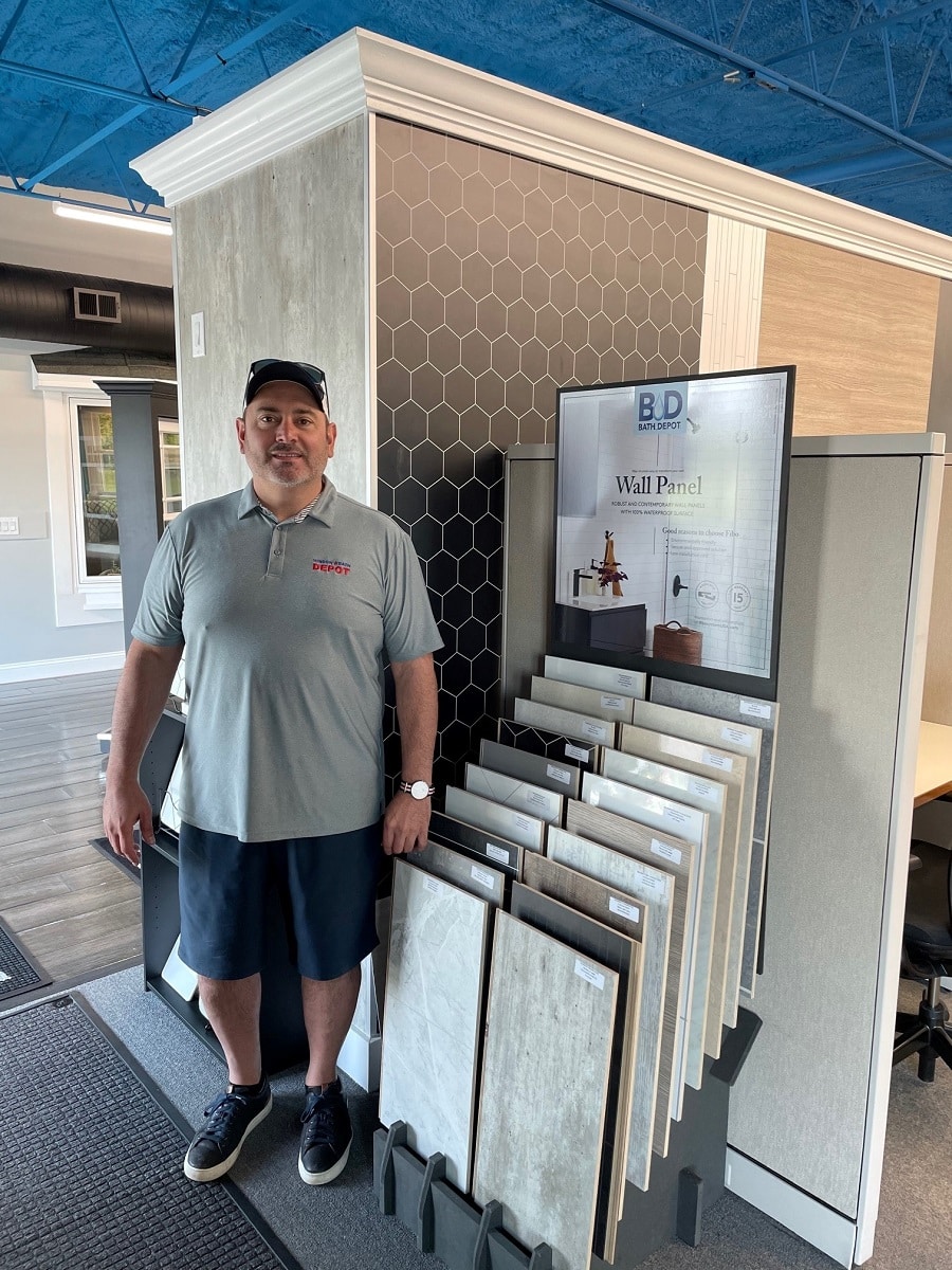 Question 7 Tony Hoty in front of laminate shower wall panel showroom display | Innovate Building Solutions #LaminateWallPanels #ShowerRemodel #BathroomRemodel