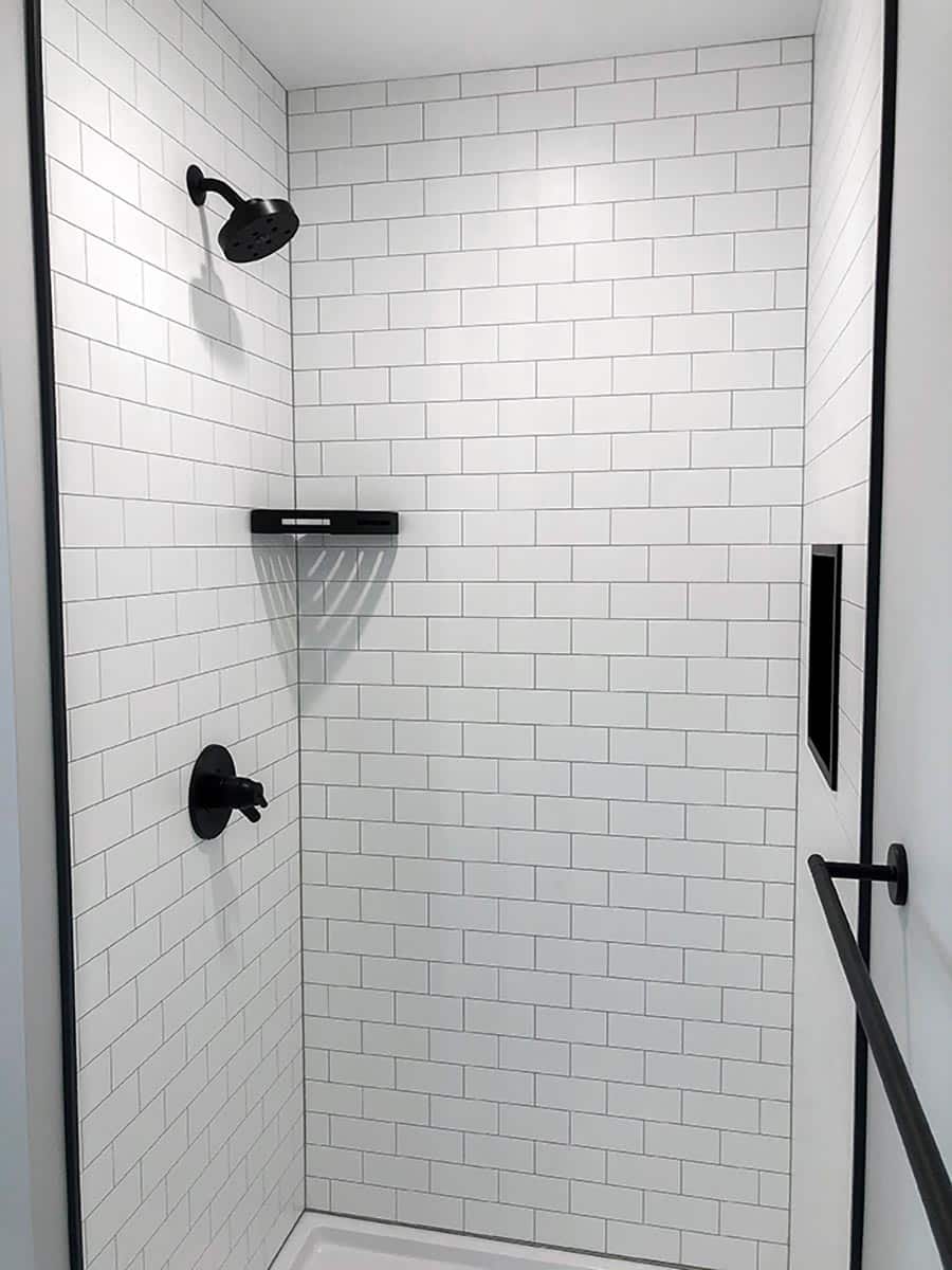 Reason 7 - White Subway Tile laminate shower panels with matte black profile | Innovate Building Solutions | bathroom remodeling contractors | wall panels for bathroom remodel | easy to install bathroom wall panels