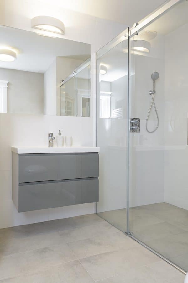 Hotel bathroom shower with laminate wall panels | Innovate Building Solutions | Innovate Multi Unit Bathroom | #HotelBathroom #LaminateShowerPanels #BathroomRemodeling