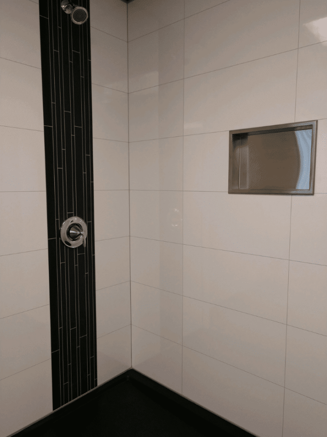 Stainless steel recessed niche laminate panels hotel bath | Innovate Building Solutions | Innovate Multi Unit | #BathroomRemodel #StainlessSteel #RecessedNiche #LaminatePanels 