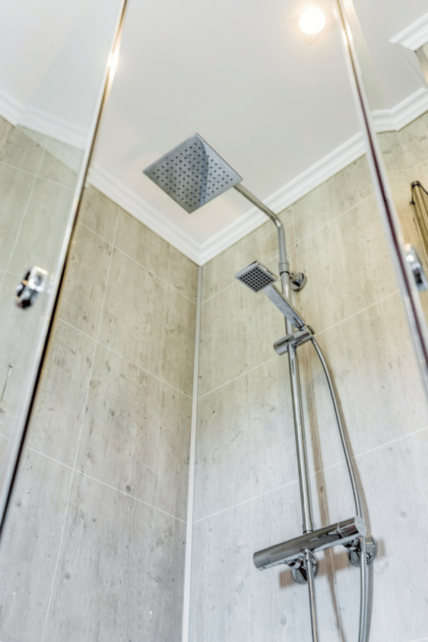 Decorative laminated wall panels in a rental home shower | Innovate Building Solutions | Innovate Building Solutions Multi Unit | #LaminateWallPanels #ShowerPanels #GroutFreePanels 