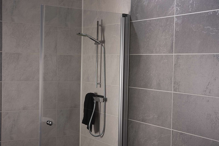 3D textured slate laminate grout free shower and bathroom wall panels | Innovate Building Solutions | Multi Unit | Luxury Apartments | #BathroomRemodel #ApartmentBathrooms #LuxuryBathrooms