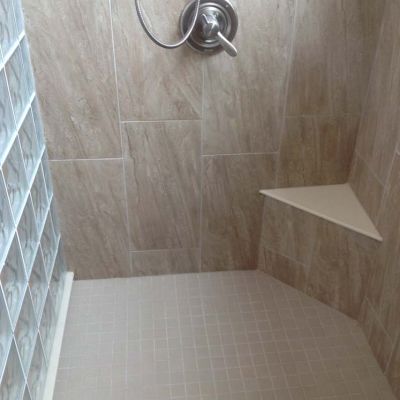 Corner seat in a glass block shower with a solid surface top