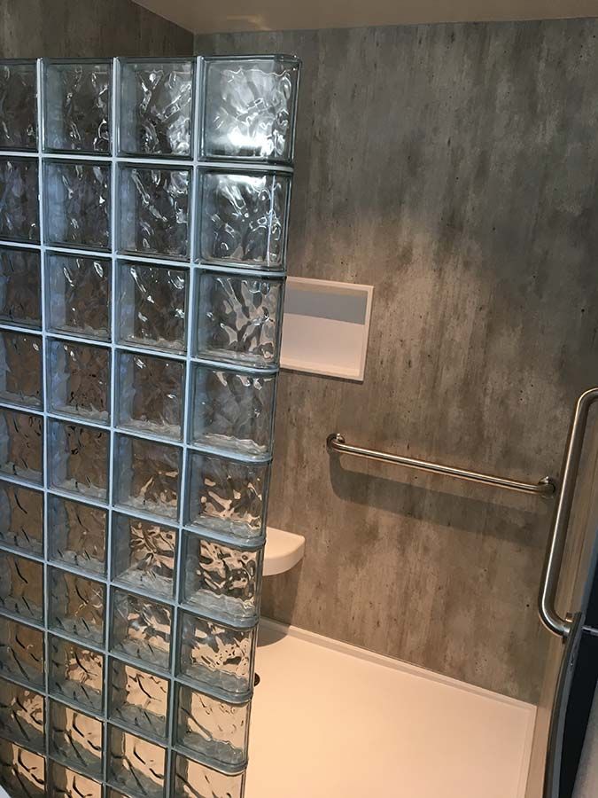 Cracked cement click together Waterproof laminate wall panels in a glass block shower - Innovate Building Solutions 