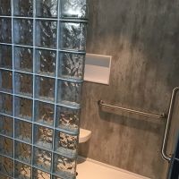 Cement look grout free shower wall panels in a walk in glass block shower - Innovate Building Solutions 
