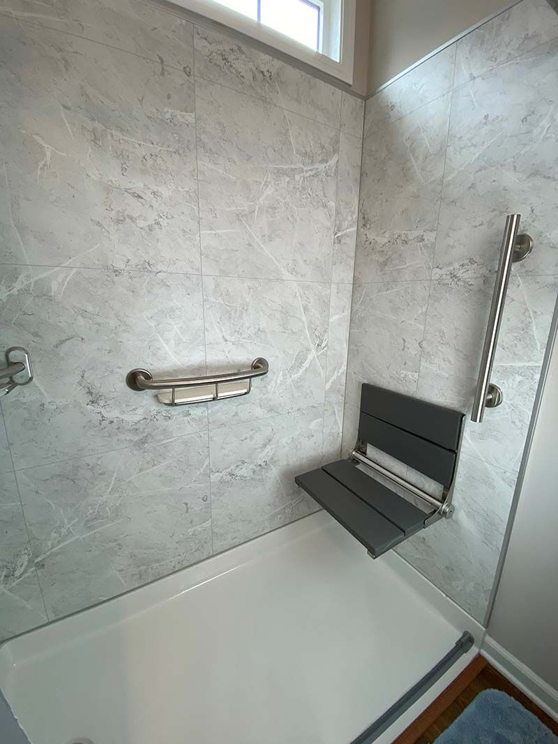 Grout-free shower wall panels and a fold out sitting bench