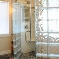 Frameless pivoting glass shower doors inside a NEO angle glass block wall system - Innovate Building Solutions 