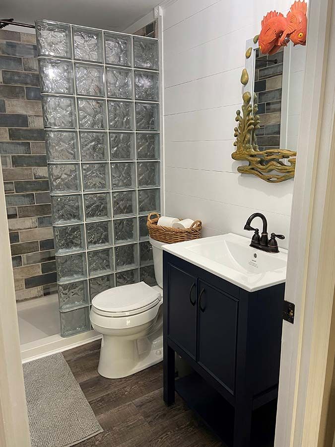 Glass block walk in shower on a solid surface base in a Rocky River small bathroom - The Bath Doctor 