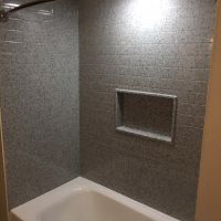 Dark gray subway tile shower wall surround panels in a bathtub alcove 