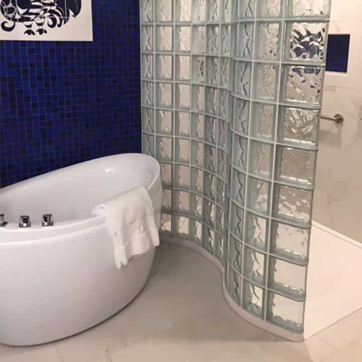 Serpentine shaped solid surface shower pan and glass block wall  by Innovate Building Solutions 