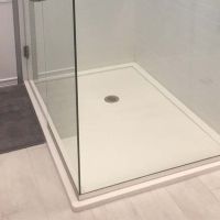 Low profile corner shower with frameless pivoting shower door and solid surface shower surround panels - The Bath Doctor South Russell Ohio 