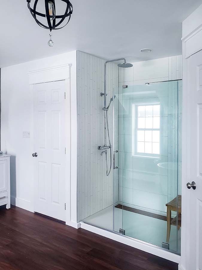 High gloss white laminate shower wall panels with a pivoting shower door in Richfield Ohio - The Bath Doctor 