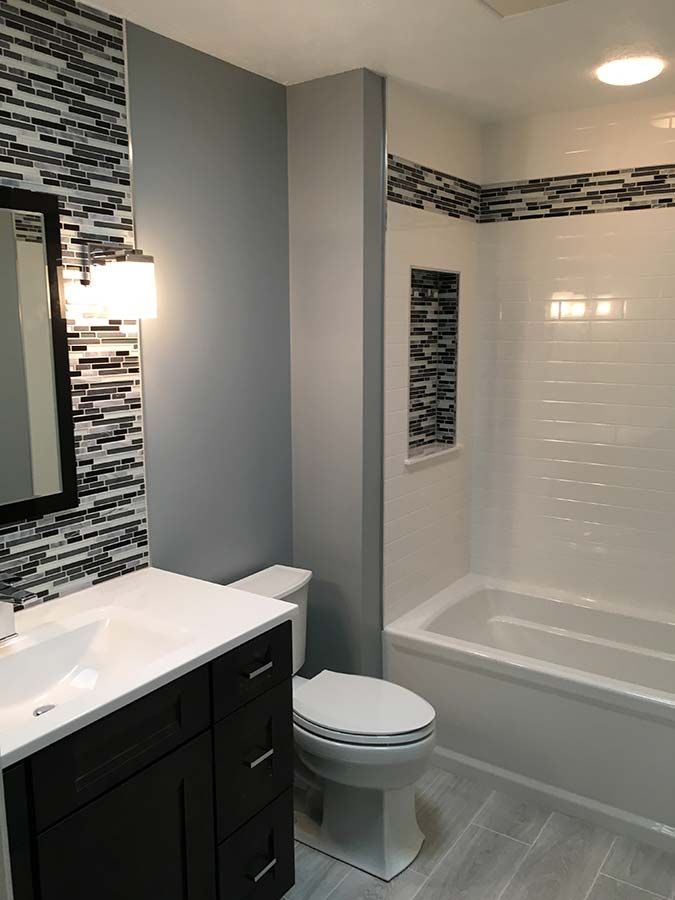 Solid surface whit subway wall surrounds and a new bathtub insert by The Bath Doctor a Cleveland replacement contractor 