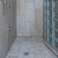 Square drain in a expanded polystyrene shower pan with a glass block wall - Innovate Building Solutions 