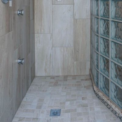 Square drain in a ready for tile glass block curved shower with 2 inch by 2 inch tiles - Innovate Building Solutions 