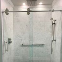 White marble 24 x 24 laminate shower panel with a sliding glass door 