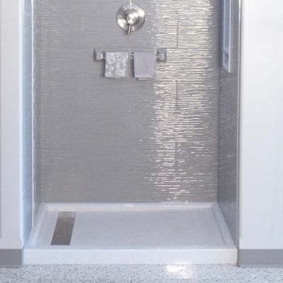 Linear drain in a white solid surface shower pan - Innovate Building Solutions 