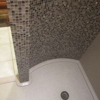 Walk in shower with a curved custom shower pan around a framed curved wall