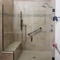 Cultured granite shower pan with tile wall surrounds and a granite bench seat 