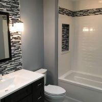 Solid surface subway tile pattern with a tile border and recessed niche in lay 