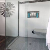 Cultured granite corner shower pan with sliding glass and a recessed niche 