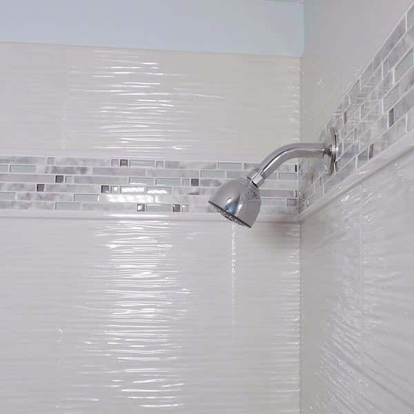 Wavy textured cultured granite shower wall panels with a decorative in lay border Westlake Ohio 