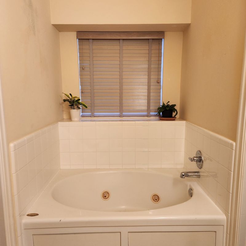 Before picture white tile jacuzzi but with a ledge | innovate building solutions | Cleveland Bathroom Services