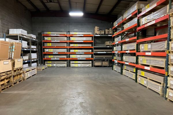 Warehouse racks with shower pans stored in wooden crates