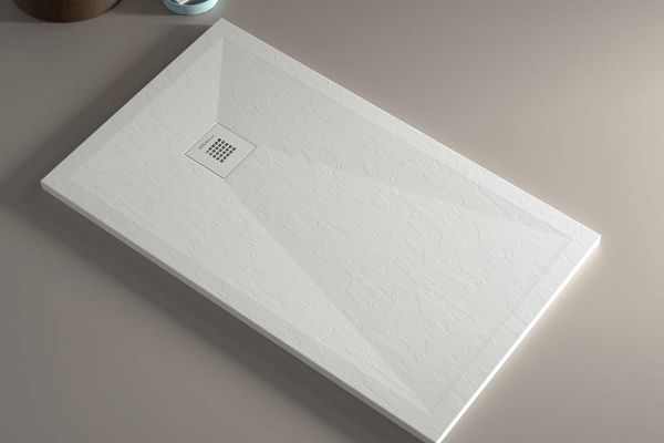 A standalone white stone low profile shower base i a 60 x 32 size and low curb entrey 