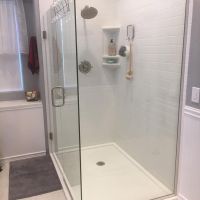 Low profile white custom corner cultured marble shower pan with a subway tile design - Innovate Building Solutions