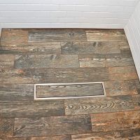 Ceramic wood look tile in a one level wet room shower floor - Innovate Building Solutions 