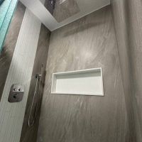 Grey Stone with Decorative White Accent and White Niche | Innovate building solutions | Grey Stone Shower Remodel | Walk in Shower | Rain shower head, bathroom diy shower remodel