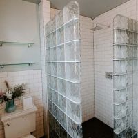 2 glass block walls in a retro boutique hotel with white subway tile - Innovate Building Solutions 