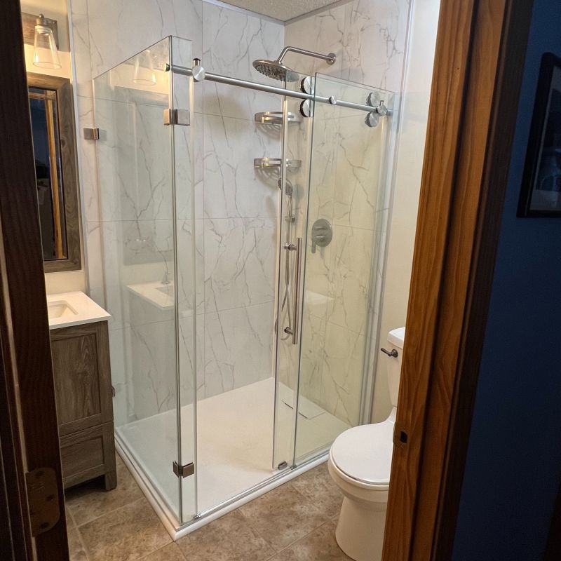 AFTER - concrete wall panels with new shower base and glass enclosure