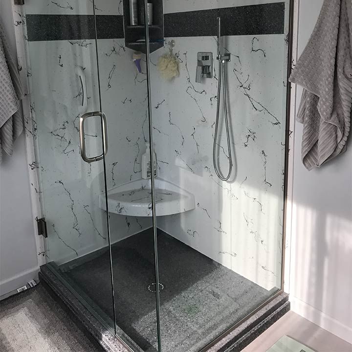 Cultured granite custom shower base with a pivoting glass enclosure - Innovate Building Solutions 