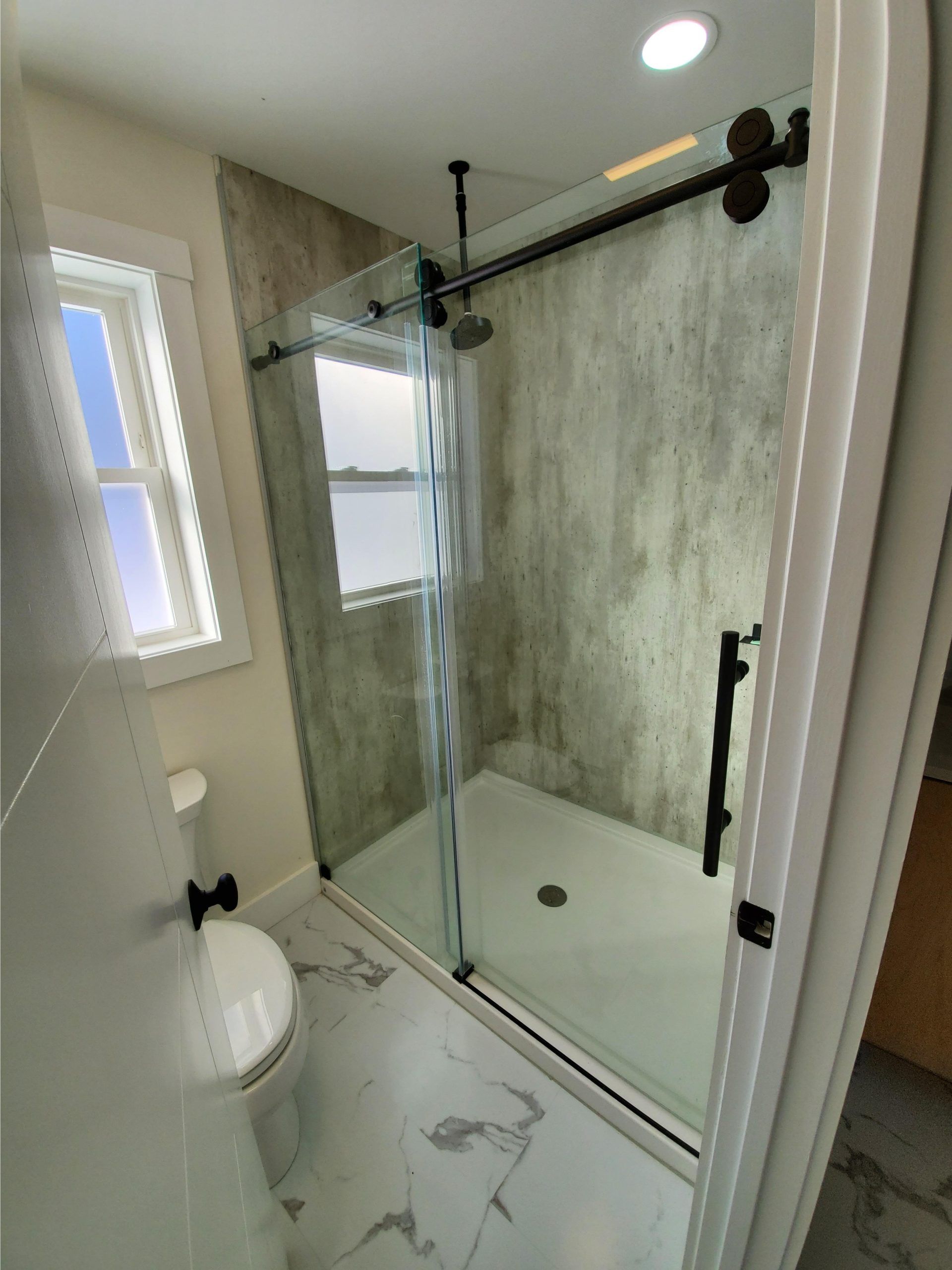 Matte black shower alcove glass Sliding doors in a remodel and shower base in Cleveland Ohio - The Bath Doctor 