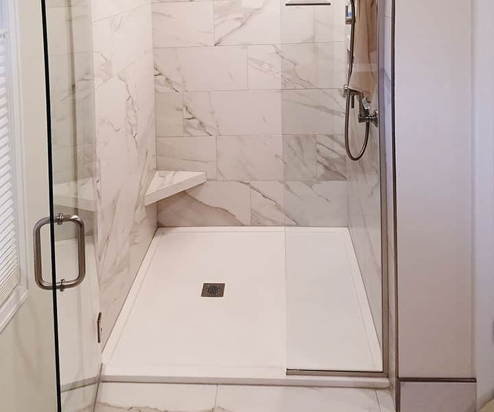 Custom sized solid surface cultured granite shower pan with a pivoting glass door Cleveland Ohio 