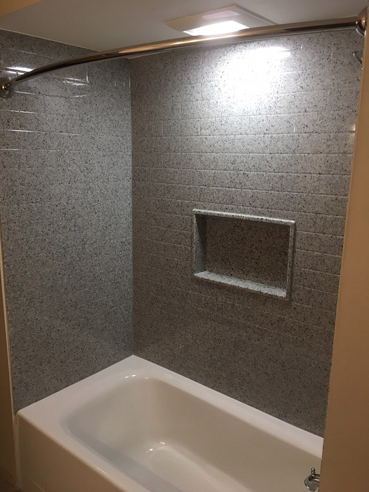 Dark gray subway tile shower wall surround panels in a bathtub alcove 