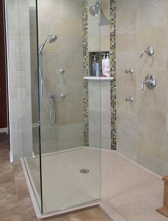 Custom solid surface shower pan with a clipped corner in a low profile design with tile walls 