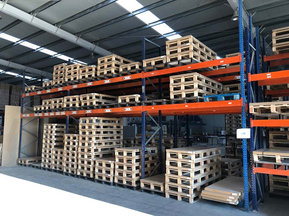 Warehouse racks with shower pans stored in wooden crates