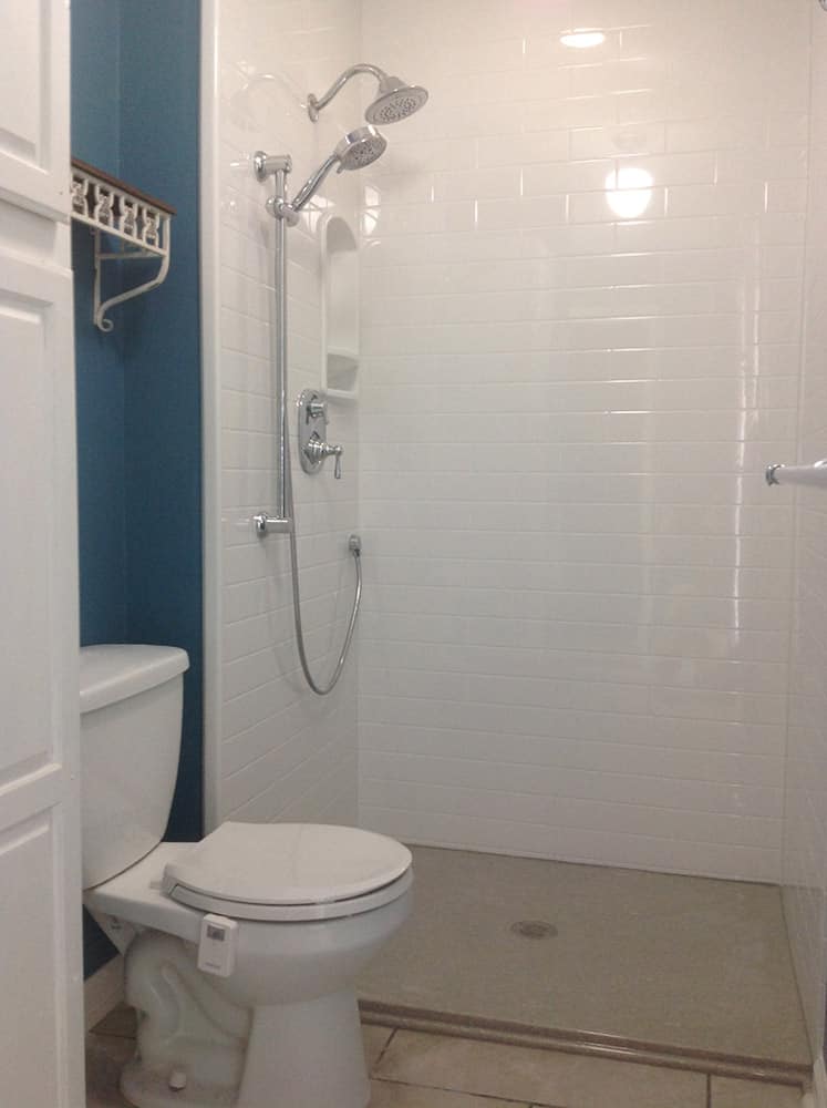 White subway tile cultured marble shower walls and a low profile shower pan 